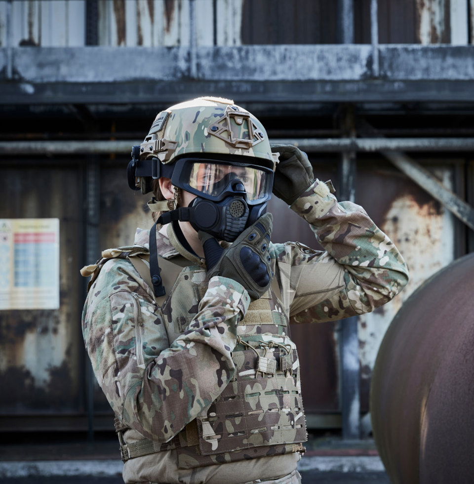 A soldier wearing a helmet and donning a respirator